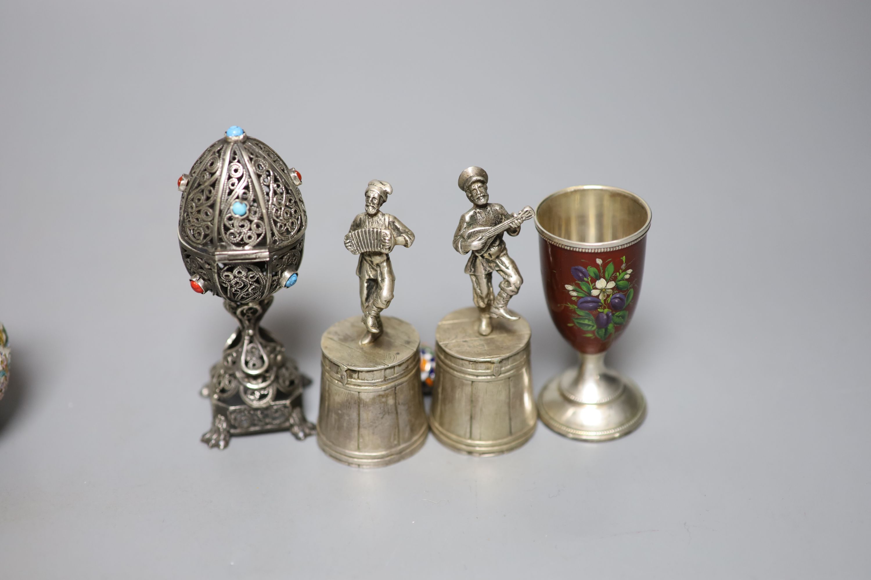 A group of Russian style white metal and enamel items including kovshs, egg pendants and small cups.